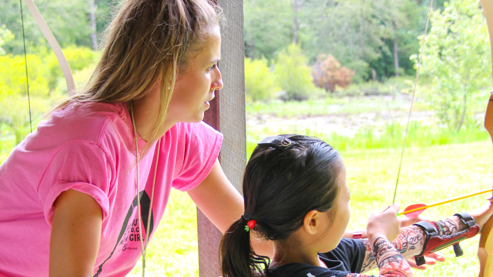 Archery lesson with child and counselor