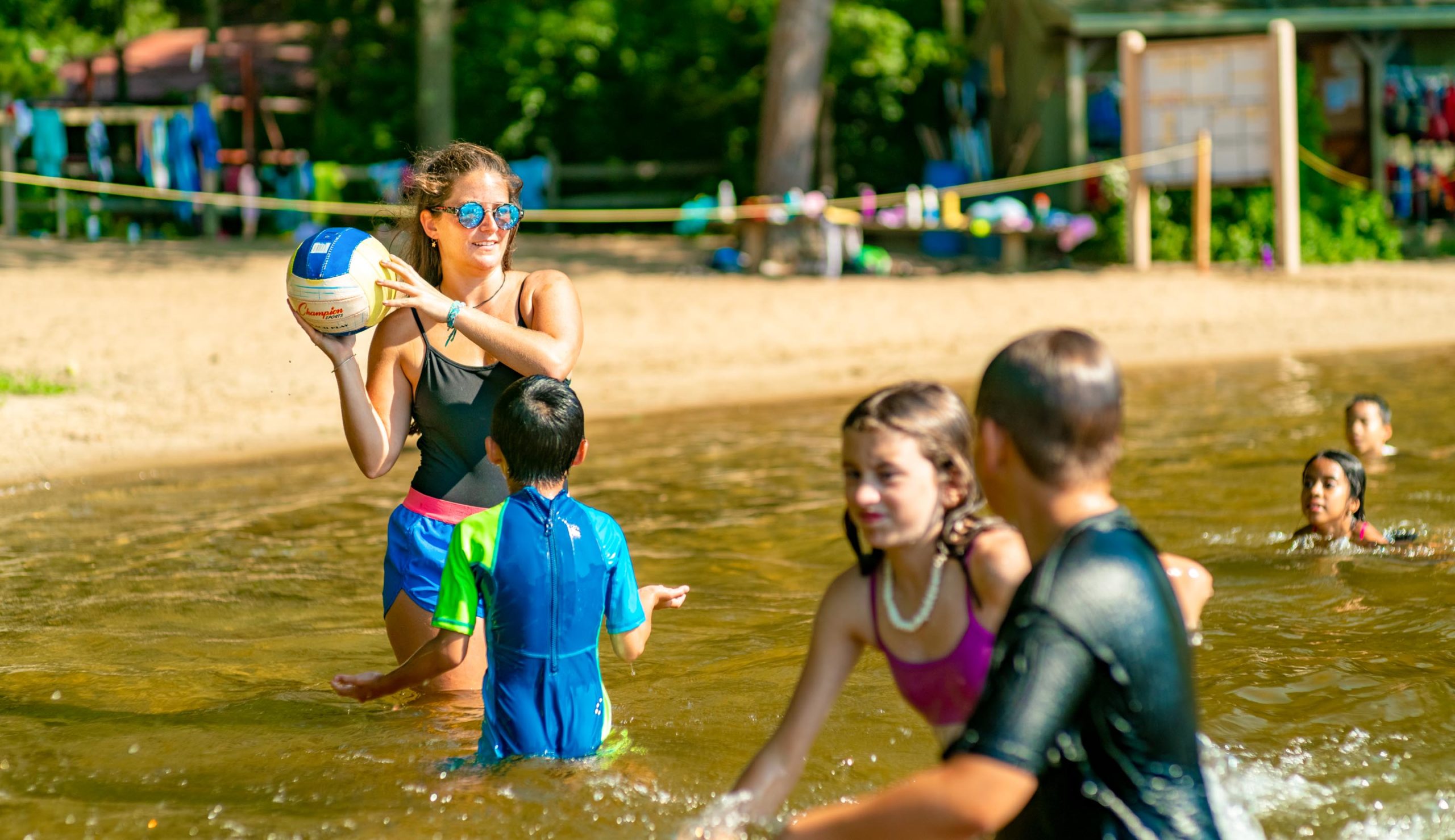 Counselor playing ball with campers in the water
