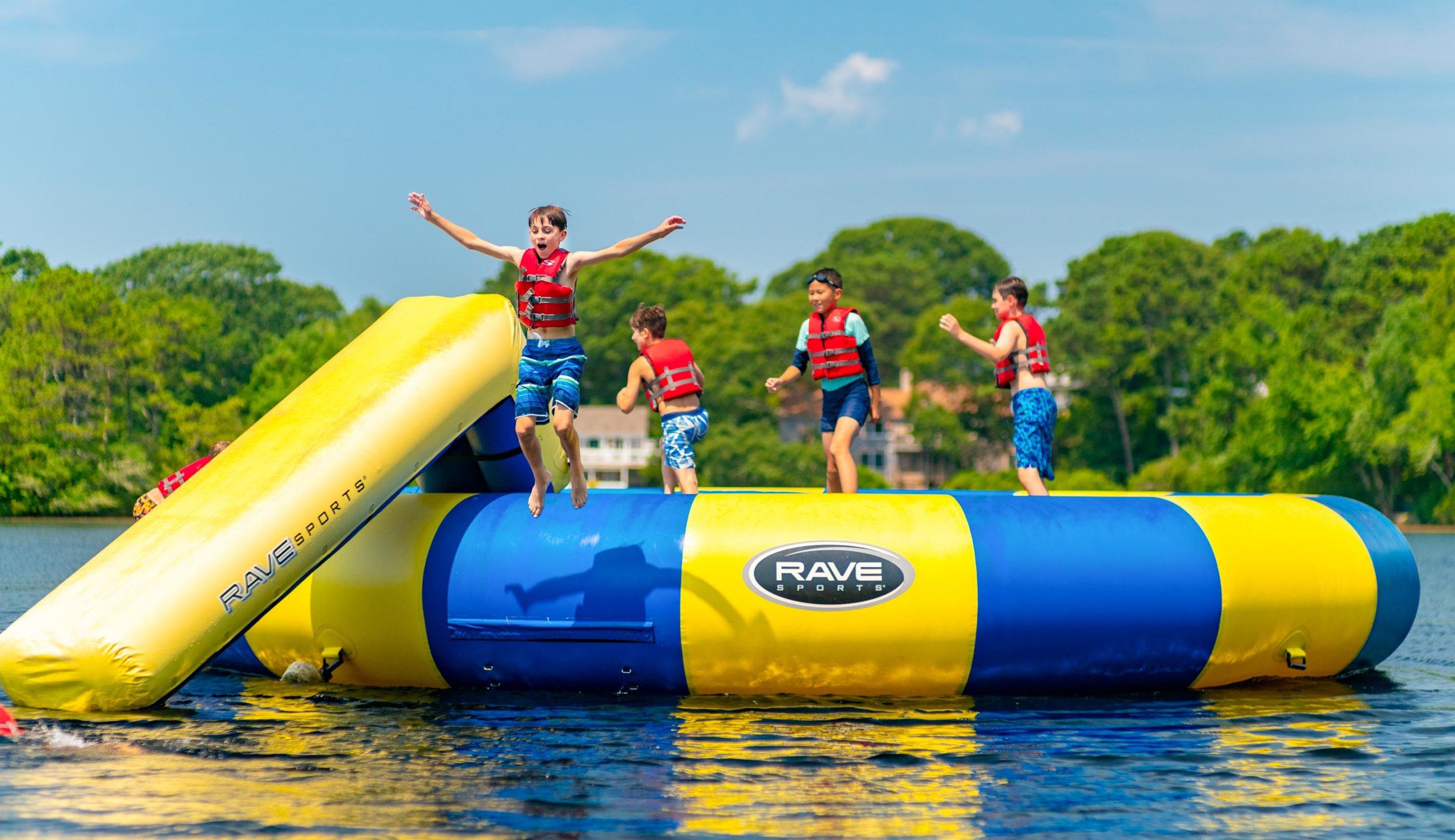 Camper jumping off of the water tampoline