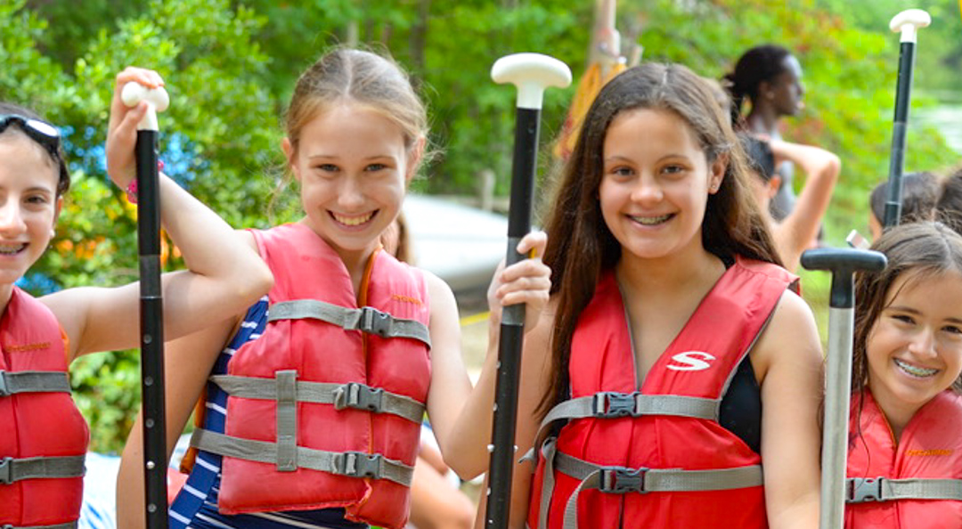 Girls holding kayak paddles