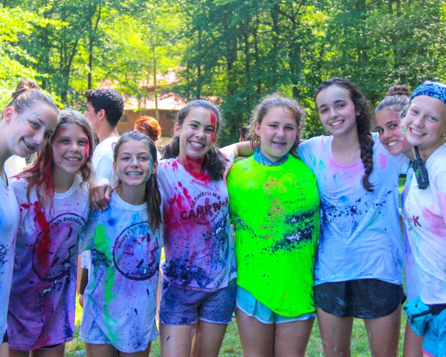 Group of girls standing together with paint on their shirts