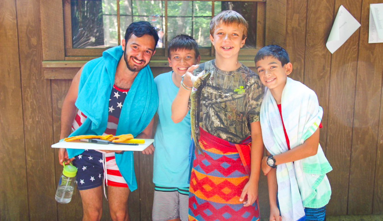 Counselor and campers wrapped in towels after swimming