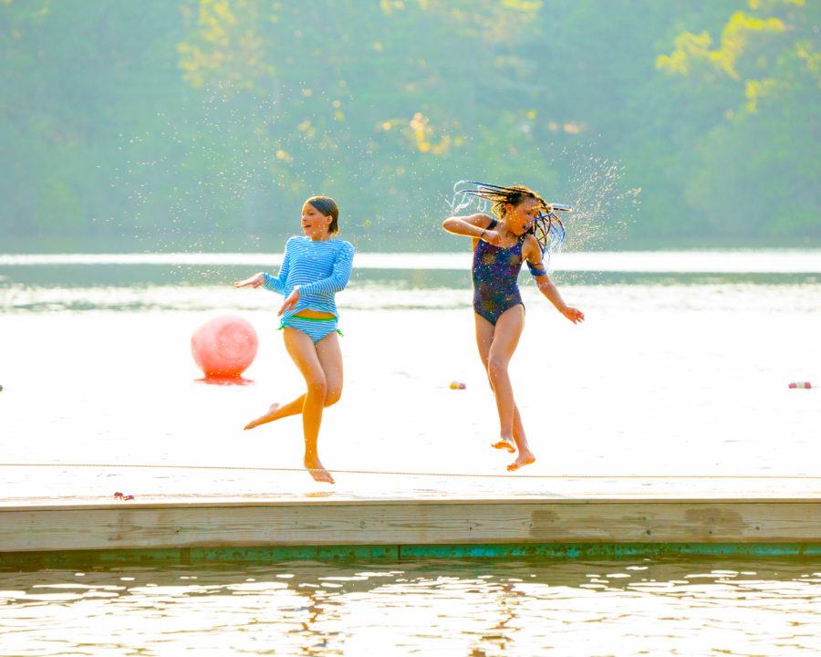 Campers jumping and spinning on the dock